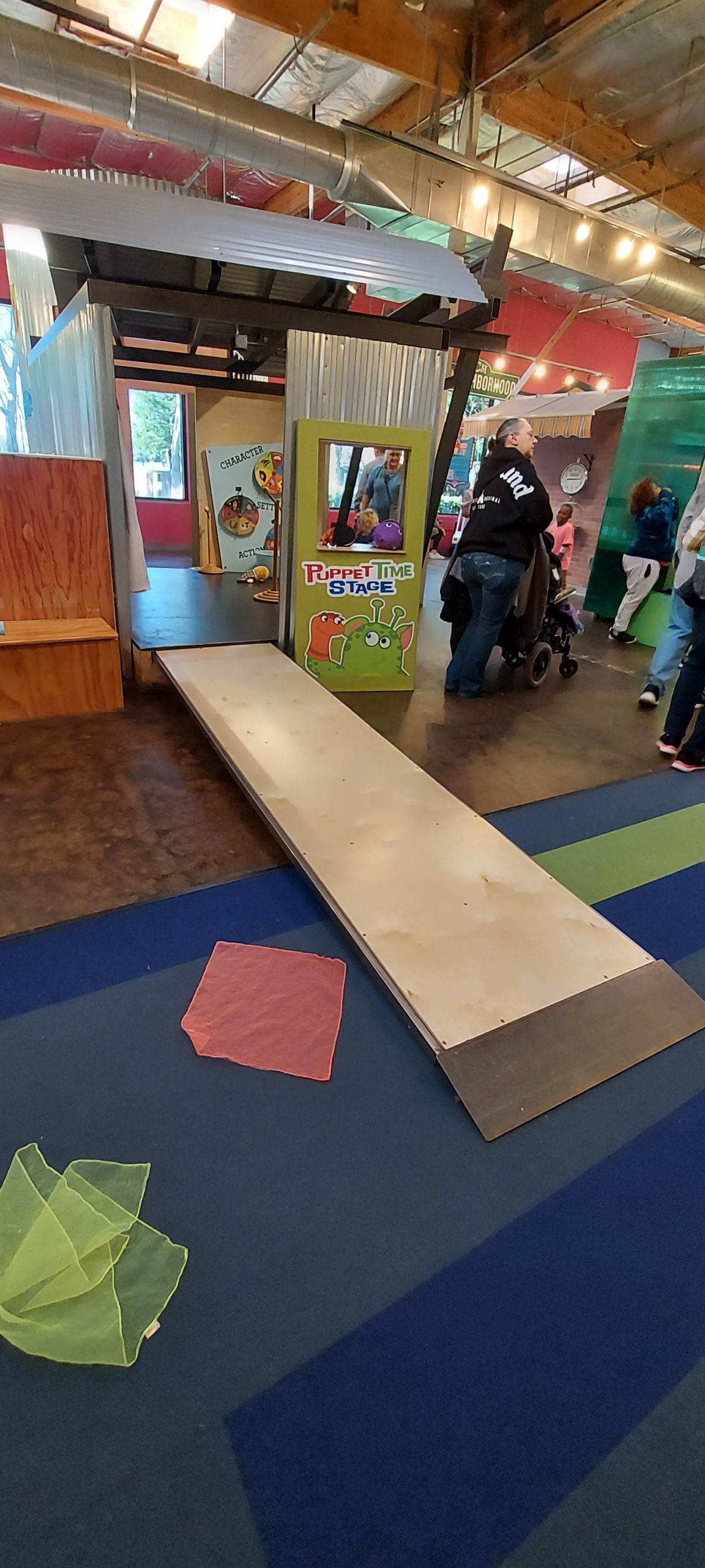 A ramp extends from a stage onto blue carpet for accessibility .