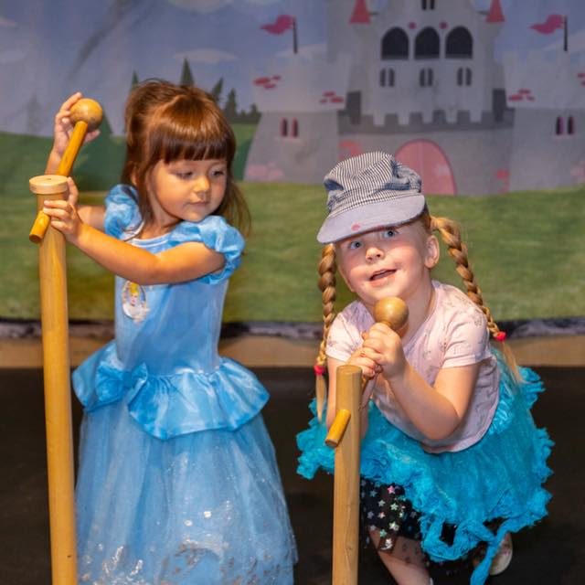 Two girls sing into the play microphones on our stage!